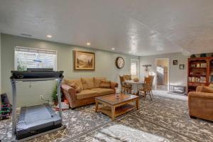 a living room with a couch and a tv at Farr West Apartment on Farm Less Than 25 Mi to Ski Resorts 