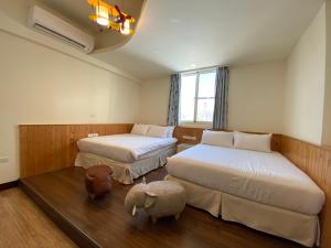 una camera d'albergo con due letti e una finestra di 台東1314電梯民宿 a Città di Taitung