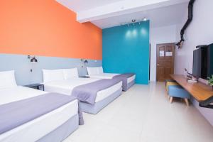 um quarto de hotel com duas camas e uma televisão em SNUG·NINE Hotel em Hengchun Old Town