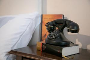 Agriturismo Tenuta Lagala في فينوسا: جلسة تلفون فوق كتاب على طاولة