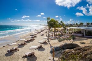 - une plage avec des chaises, des palmiers et l'océan dans l'établissement Esmeralda Resort, à La Baie-Orientale