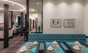 a dining room with a blue couch and tables at Montfleuri in Paris