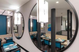 a dining room with a mirror on the wall at Montfleuri in Paris