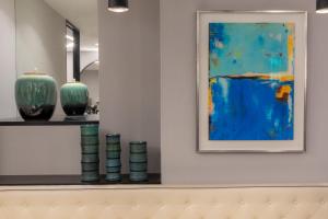 a painting on a wall next to vases on a shelf at Montfleuri in Paris