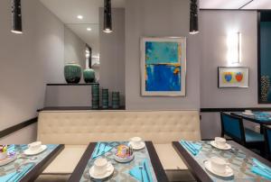 a dining room with a bench and a table with dishes on it at Montfleuri in Paris