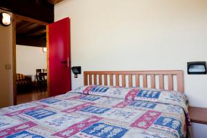 een slaapkamer met een bed met een kleurrijke quilt bij Residence Savoia in Passo del Tonale