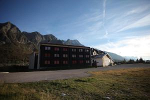 un bâtiment marron avec des montagnes en arrière-plan dans l'établissement Residence Savoia, à Passo del Tonale