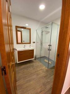 La salle de bains est pourvue d'une douche, d'un lavabo et d'un miroir. dans l'établissement Casas Rurales Laguna La Tinaja, à Ossa de Montiel