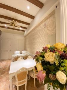 una sala da pranzo con un tavolo bianco e fiori di 台東1314電梯民宿 a Città di Taitung