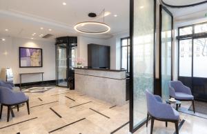 a lobby with blue chairs and a reception desk at Montfleuri in Paris