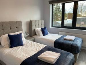 1 dormitorio con 2 camas y ventana en Zen Quality flats near Heathrow that are Cozy CIean Secure total of 8 flats group bookings available, en Hounslow