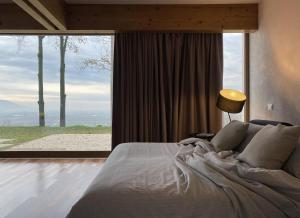 1 dormitorio con cama grande y ventana grande en Dal Gheppio - Nido con vista, en Albettone