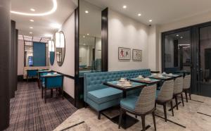 a restaurant with a blue booth and tables and chairs at Montfleuri in Paris