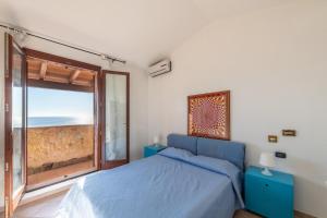 a bedroom with a bed with a view of the ocean at il Pashà in Villaputzu