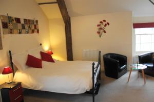 a bedroom with a large white bed with red pillows at The Olive Branch in Ilfracombe