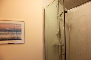 a bathroom with a shower and a painting on the wall at The Olive Branch in Ilfracombe