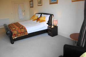 a bedroom with a bed with yellow pillows and a table at The Olive Branch in Ilfracombe