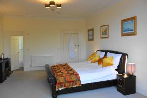 a bedroom with a large bed with yellow pillows at The Olive Branch in Ilfracombe