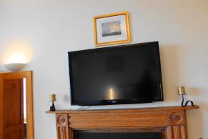 a flat screen tv sitting on top of a fireplace at The Olive Branch in Ilfracombe