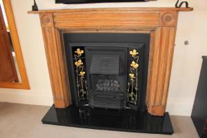 a fireplace with a wooden frame with flowers on it at The Olive Branch in Ilfracombe