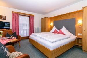 a hotel room with a large bed and a desk at Ferienhaus Ostara GbR in Ruhpolding