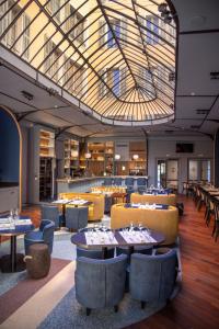 un restaurant avec des tables et des chaises et une grande lucarne dans l'établissement L'Eautel Toulon Centre Port, à Toulon