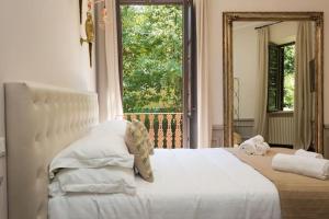 een slaapkamer met een wit bed en een groot raam bij Beyond Colosseum in Rome