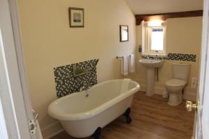 a bathroom with a tub and a toilet and a sink at The Olive Branch in Ilfracombe