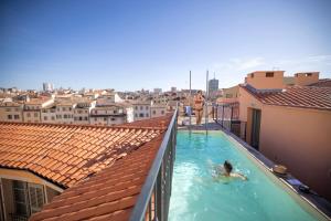 una persona en una piscina en la parte superior de un edificio en L'Eautel Toulon Centre Port en Toulon