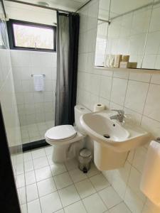 een witte badkamer met een toilet en een wastafel bij Hotel Zee Bergen in Bergen