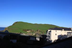 a view of a green hill with a house at The Olive Branch in Ilfracombe
