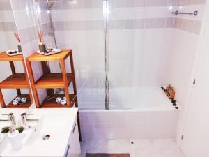 a bathroom with a shower and a tub and a sink at The Surf Studio - Ericeira in Ericeira