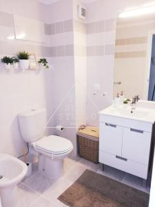 a white bathroom with a toilet and a sink at The Surf Studio - Ericeira in Ericeira