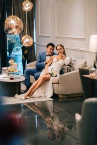a bride and groom sitting on a couch at Boutique Hotel Vissi d'Arte in Budva