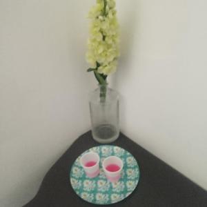 a table with two cups and a vase with flowers at Boel Boutique Hostal in Guayaquil