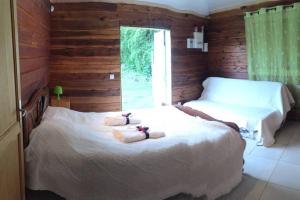 a bedroom with two beds and a window at Ti' case la plaine in La Plaine des Palmistes