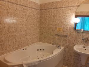 La salle de bains est pourvue d'une baignoire et d'un lavabo. dans l'établissement Hotel Uno, à Ústí nad Orlicí