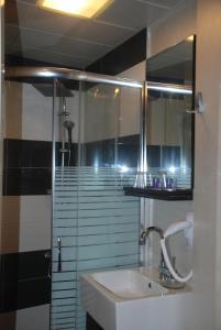 y baño con lavabo y ducha con espejo. en Mini Hotel, en Izmir
