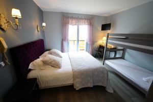 a bedroom with a bed and a window at Logis Hôtel Le Griou in Saint-Jacques-des-Blats