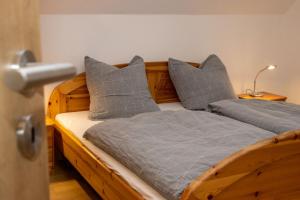 a wooden bed with gray pillows in a bedroom at Xavers Ranch in Meschede +153 photos