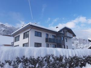 a building in the snow with a fence in front of it at Apart Pitztalurlaub in Wenns