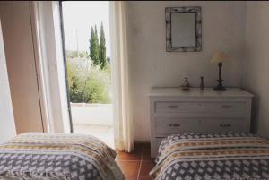 a bedroom with a bed and a dresser and a window at Cortijo el Abejaruco in Almuñécar +28 photos