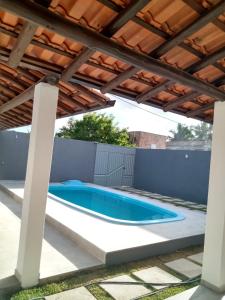 聖克魯斯－卡布拉利亞的住宿－Casa individual com piscina e area gurmet，后院的游泳池,带凉棚