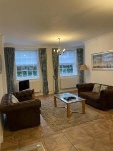a living room with two couches and a coffee table at Ebury Hotel Cottages and Apartment's in Canterbury