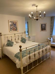 a bedroom with a large bed with a chandelier at Ebury Hotel Cottages and Apartment's in Canterbury