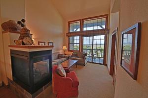 a living room with a fireplace and a living room with a fire place at Kicking Horse Lodges 4-302 in Granby