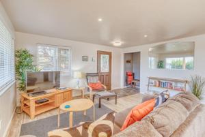 a living room with a couch and a tv at Sandy Feet in Nehalem