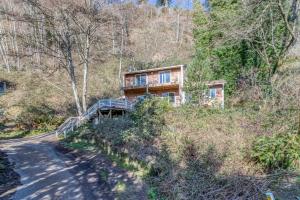 a house on the side of a hill with a road at 38445 Reed - Meredith Lodging in Manzanita