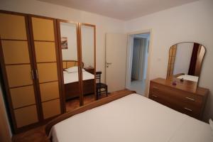Schlafzimmer mit einem Bett, einer Kommode und einem Spiegel in der Unterkunft Apartman Antea in Trogir