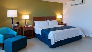 um quarto de hotel com uma cama e uma cadeira em Holiday Inn Express Cabo San Lucas, an IHG Hotel em Cabo San Lucas
